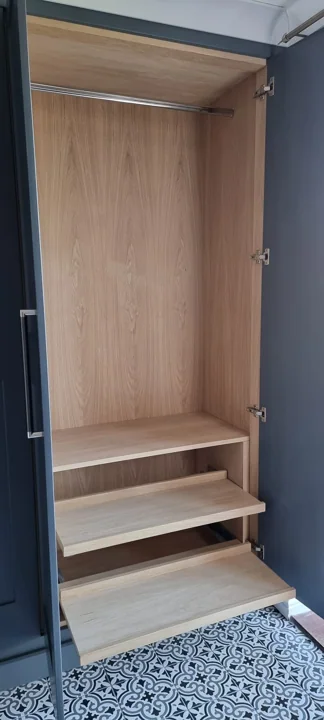 Open fitted wardrobe with natural wood interior and shelves